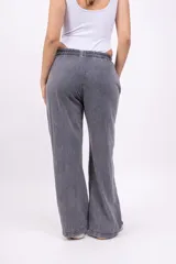 Pantalón deportivo gris con efecto lavado, corte ancho, cintura elástica y logo bordado en negro.