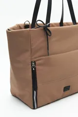 Bolso tote negro de nylon con diseño acolchado, asas largas para llevar al hombro, cierres metálicos laterales y detalle de cordón.