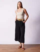 Pantalón capri negro de gasa bambula marca Dictionary. Tiene pretina ancha, pretina trasera elastizada y bolsillos delanteros. El modelo es de pierna ancha e incluye cinturón.