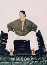 Chaqueta bomber verde oliva de lana con cierre frontal con cremallera, cuello redondo, puños y bajo elásticos.