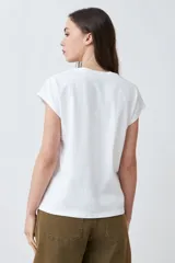 Remera color durazno con escote en V y detalle de vainillas en los laterales. De manga corta y corte recto.