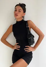 Mono corto negro ajustado al cuerpo, sin mangas y con cierre frontal.