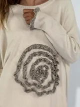 Sweater azul con diseño de flor en el frente y detalles de volados en puños y ruedo.