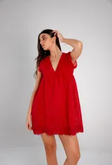 Vestido corto bordó con calados, escote en V y mangas cortas con volados.