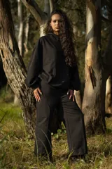 Pantalón ancho negro de algodón con cintura elástica y dos cortes estéticos delanteros.