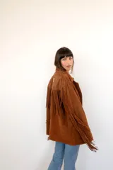 Blazer marrón de gamuza con flecos en la espalda y mangas largas.