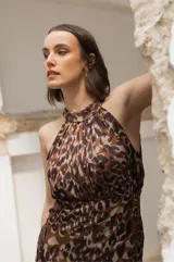 Vestido largo de seda estampada con animal print, escote halter regulable y falda fluida con tableado a mano en el frente.