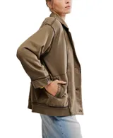 Chaqueta estilo blazer de algodón color marrón oliva, con efecto desgastado y costuras marcadas. Presenta solapas anchas, cierre frontal de dos botones y puños anchos ajustables con botón.