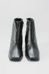 Botas cortas de cuero negro con cierre lateral y taco de madera.