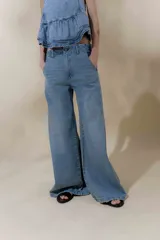Pantalón de jean celeste, de tiro medio y corte acampanado, con bolsillos delanteros y traseros.
