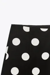 Shorts negros con estampado de lunares blancos, de tiro alto y cierre lateral con cremallera oculta.