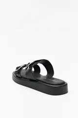 Sandalias marrones con plataforma baja y tiras anchas con hebillas metálicas.