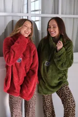 Buzo verde de peluche corderito con cierre parcial en el cuello y logo cuadrado en el pecho.