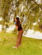 Pantalón de jean con estampado animal print en tonos beige y negro, de corte ancho y tiro medio. Presenta detalles de cuero bordó en la pretina y los bolsillos.