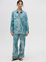 Camisa oversize celeste con estampado tie-dye, bolsillo en el pecho con bordado y terminaciones con ribete en contraste.