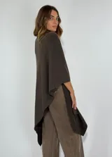 Poncho en color chocolate con diseño asimétrico y cuello alto.