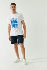 Bermuda de jean celeste con bolsillos delanteros y traseros, cierre con cremallera y presillas para cinturón.