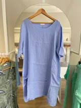 Vestido celeste de lino, corte oversize, con mangas cortas y bolsillos laterales.
