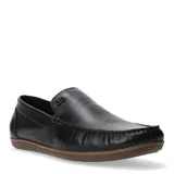 Mocasines de cuero negros para hombre, estilo chato, con costura visible en la puntera y detalle metálico con logo en el empeine. Suela de goma marrón.