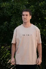 Remera color beige de manga corta con cuello redondo y estampado frontal con la frase 'setenta treinta'.