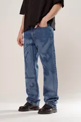 Pantalón de denim azul con diseño abstracto en tono más claro, de corte wide leg y cinco bolsillos.