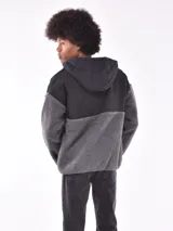 Campera con capucha, color gris oscuro, con paneles de tela tipo polar y tela lisa.