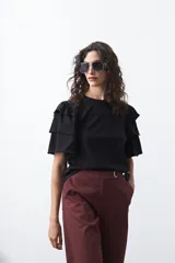 Remera negra de algodón con cuello redondo y mangas cortas con volados en capas.