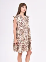 Vestido negro corto con volados en las mangas y escote en V con botones. El cuerpo es suelto con un corte a la altura de la cadera que genera un volante fruncido en la falda.