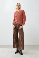 Sweater de punto color ladrillo, con cuello redondo y ruedo curvo.