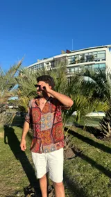 Camisa de manga corta con estampado de mosaicos en tonos rojo, naranja, azul y blanco.