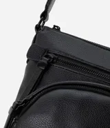 Bolso tipo postman negro, confeccionado en poliuretano, con bolsillo delantero y correa ajustable.