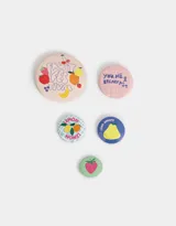 Set de cinco pins con diferentes diseños estampados de frutas y frases.