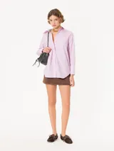 Camisa de poplin rayada rosa y celeste, de corte holgado, con cuello clásico, cierre frontal con botones y bolsillo plaqué en el pecho.