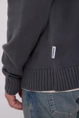 Cárdigan gris de punto con cierre de cremallera, cuello alto y mangas largas.