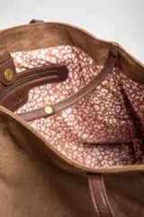 Bolso tipo tote de gamuza vegana color camel, con asas de mano y logo grabado en el frente.