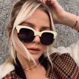 Lentes de sol cuadrados con armazón bicolor: parte superior color crema y parte inferior con estampado carey. Lentes polarizados negros con protección UV400.