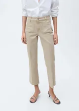 Pantalón de jean color beige, de corte recto, con bolsillos de parche delanteros y terminación desflecada.