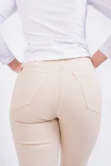 Pantalón Oxford color beige con corte ajustado en la parte superior y acampanado con aberturas en el ruedo.
