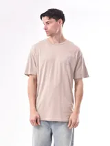Remera color beige con estampado pequeño en el frente.