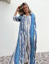 Vestido camisero largo con estampado batik en tonos celeste y blanco, con cuello camisero, mangas largas con puños y cierre frontal con botones.