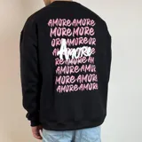 Buzo blanco de cuello redondo y corte oversize, con estampado en la espalda de la palabra "Amore" en rosa y negro.