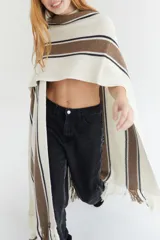 Ruana artesanal color beige con rayas horizontales rojas y amarillas, y flecos en el borde inferior.