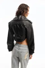 Campera corta de cuero ovino italiano color negro, con silueta tipo corsetera, cierre metálico frontal, mangas anchas fruncidas y forro de acetato con logo Ginebra.