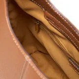 Bolso tipo hobo de cuero sintético (PU) color marrón habano, con textura granulada. Presenta costuras verticales en el centro y un logo metálico XL en la parte inferior frontal. Incluye un asa corta fija y una correa larga desmontable y regulable con diseño tejido a rayas blancas y negras.