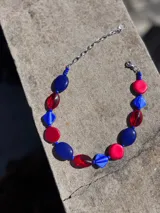 Collar corto con cuentas de cristal checo color rojo, azul y celeste, con cadena de acero quirúrgico y ganchito para regular el largo.