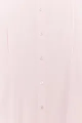 Camisa rosada de corte holgado, con cuello solapa, cierre frontal con botones y mangas cortas.