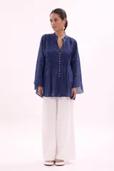 Camisa azul con cuello mao, abotonada al frente y mangas largas.