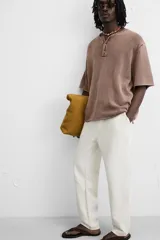 Pantalón color arena de corte recto, confeccionado en tejido de algodón y lino. Cuenta con cintura elástica ajustable con cordón, bolsillos delanteros y traseros de parche.