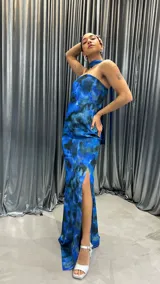 Vestido largo strapless con estampado abstracto en tonos azules y negros. Presenta un tajo lateral y un choker al tono.