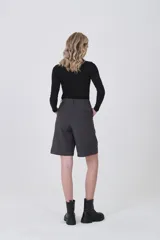 Bermuda de poliéster color gris oscuro, con pinzas frontales y corte holgado. Presenta un calce a media pierna.